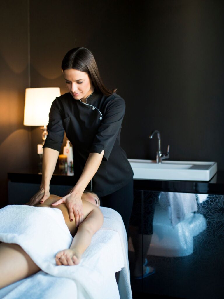 여자마사지 관리사가 누워있는 손님의 등 마사지를 하는 장면